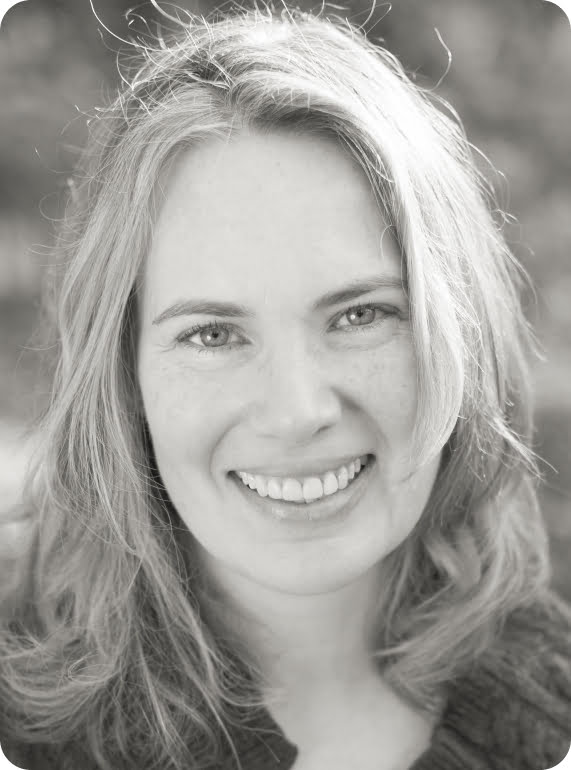 black and white headshot of Michèle smiling into the camera