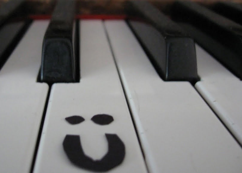 close up of a smiley face on a piano key