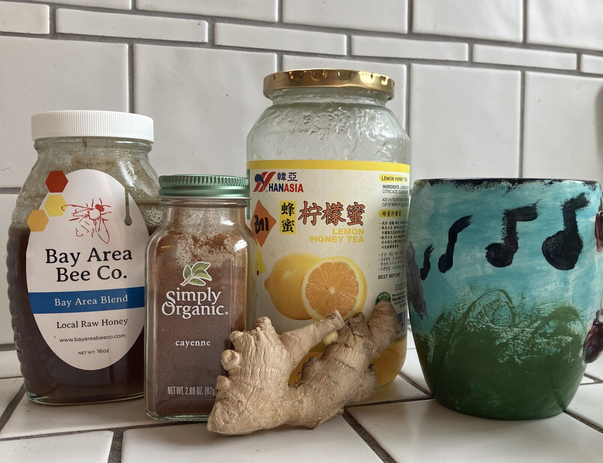 jars of honey, cayenne, and honey-lemon tea; a piece of fresh ginger and a mug with note-shaped clouds floating through the sky